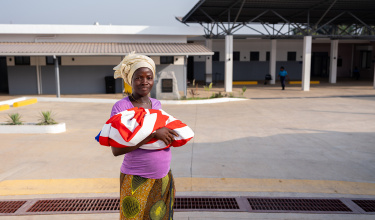 Jeneba Koroma holds her newborn son outside the MCOE