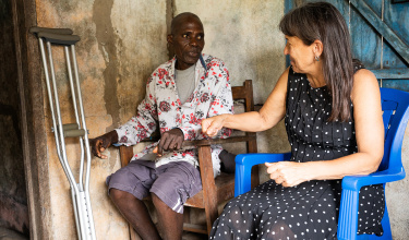 Dr. Joia Mukherjee (right), PIH’s senior clinical and academic advisor, visits with Williams Kennedy (left) at his home in Harper City, Liberia.